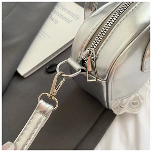 Dettaglio della borsa Boston argento con bordo in pizzo bianco e finiture metalliche lucide