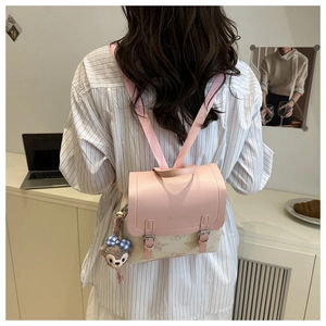 Detailed back view of pink and beige floral mini backpack with cute teddy charm