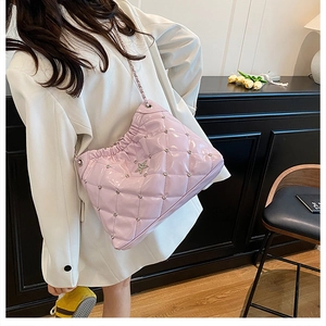 Detail of light purple glossy quilted shoulder bag with silver star and chain strap