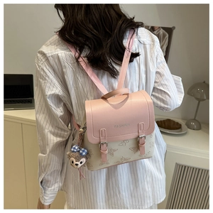 Detail of pink and beige mini backpack featuring butterfly print and fashion logo