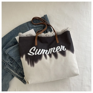 Detail of canvas tote with Summer print, fringed edges and brown faux leather handles
