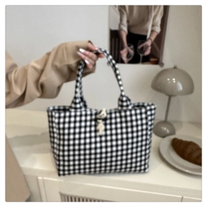 Dettaglio della classica borsa tote in tela gingham bianca e nera con manici robusti