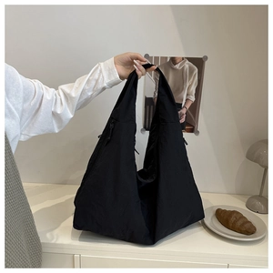 Detailed view of a black large capacity nylon tote bag with wide shoulder strap