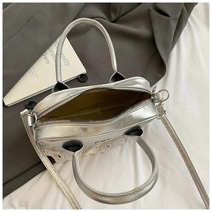 Dettaglio della borsa Boston argento con pizzo bianco a cuore e chiusura a cerniera