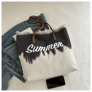 Detail of canvas tote bag with Summer print, fringed edges and brown leather handles