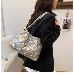 Detail shot of a silver quilted bucket bag with star ornament and metal chain strap