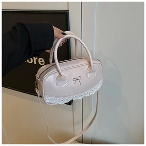 Dettaglio borsa Boston rosa con logo a fiocco in metallo e bordo in pizzo bianco