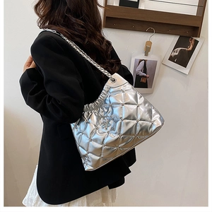 Close-up of silver quilted chain bag with star charm and metallic texture detail