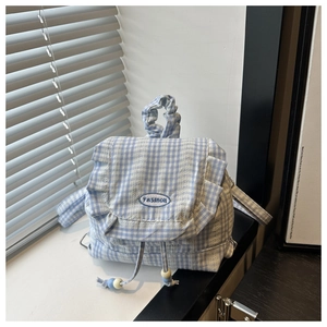Detail of blue gingham backpack featuring ruffle edges and beaded drawstring closure