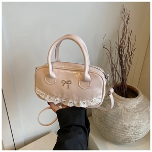 Dettaglio della mini borsa Boston rosa con pizzo delicato e fiocco in metallo