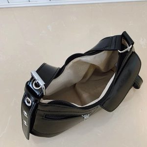 Black crescent underarm bag with silver hardware and interior compartment shown from above