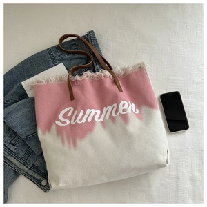 Detail of pink canvas tote with leather handles and Summer print on textured background