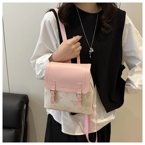 Close-up of pink and white mini backpack with embossed butterflies and gold buckles