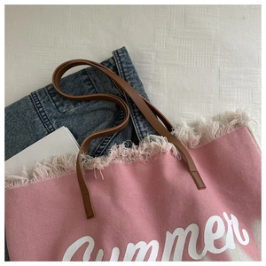 Pink canvas tote bag featuring white Summer lettering and fringe details for beach travel
