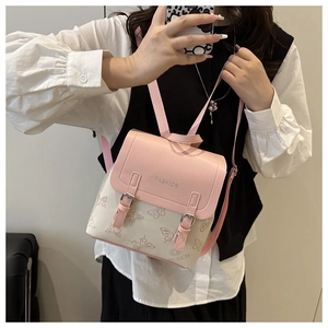 Detail of pink and beige PU leather backpack featuring butterfly pattern and metal buckle