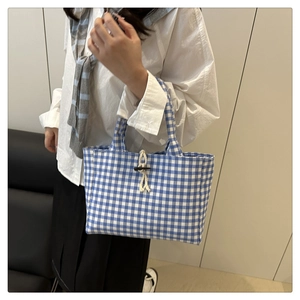 Dettaglio della borsa tote a quadretti blu con chiusura in corda e fibbia in corno
