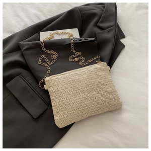 Détail du sac à bandoulière tissé crème avec chaîne dorée et fermeture éclair élégante