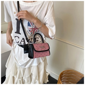 Pink crossbody bag with black heart polka dots and silver bow detail worn by model
