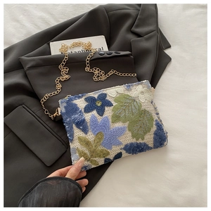 Détail de la broderie florale et des paillettes sur le sac bandoulière avec chaîne dorée