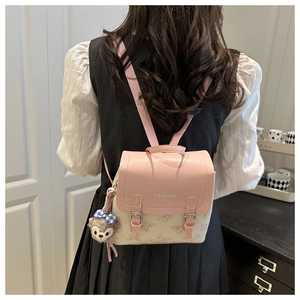 Detail view of pink embossed backpack with butterfly patterns and plush bunny charm