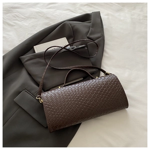 Dettaglio della trama in pelle intrecciata marrone di una borsa a tracolla alla moda