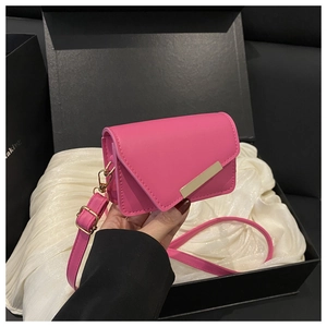 Detailed macro of a rose pink mini crossbody bag with gold hardware in a gift box