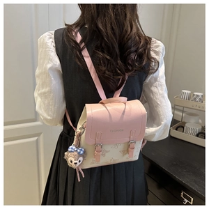 Mini pink and beige backpack with butterfly prints and plush charm shown on model