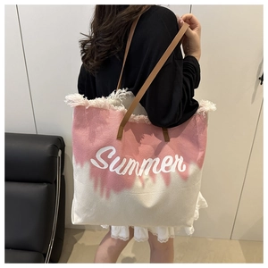 Macro view of pink gradient canvas tote bag with Summer text and fringe detail