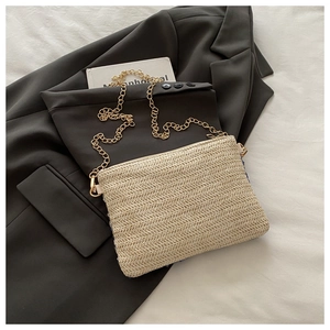 Vue détaillée d'un sac à main beige tissé avec texture en V sur blazer gris