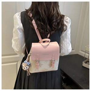Close-up of pink and beige mini backpack with butterfly print and plush keychain
