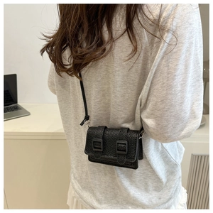 Vista laterale della mini borsa a tracolla nera con trama martellata e fibbie decorative