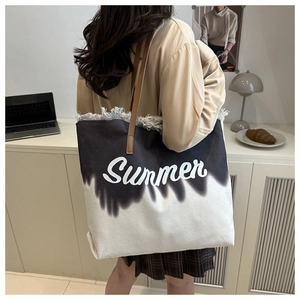 Detail of canvas tote with Summer print, fringe edges and brown leather strap on shoulder