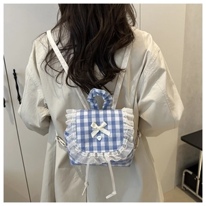 Detail shot of a sweet plaid mini backpack with white lace trim and cute bow accent