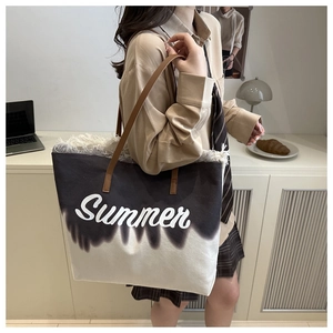 Detailed view of tie-dye canvas tote bag with Summer embroidery and fringe edge