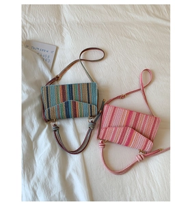 Detail of colorful woven crossbody bags showing intricate texture and boho knot straps
