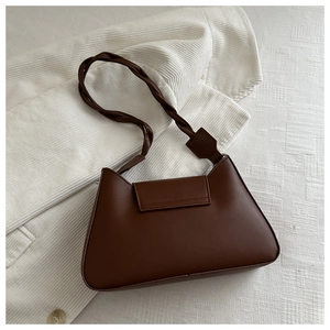 Detail of dark brown vintage underarm bag featuring a unique braided knot handle design