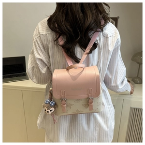 Detail view of butterfly print backpack with pink flap and fashion embossed text