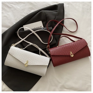 Dettaglio di borse intrecciate in beige e rosso con fibbie metalliche dorate a infinito