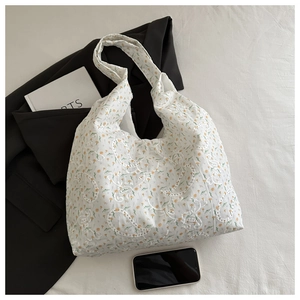 Gros plan du sac en toile blanc avec fleurs jaunes et broderies de dentelle délicates