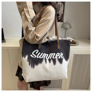 Detail of canvas tote bag with tie-dye print, Summer text, and fringe edge detailing