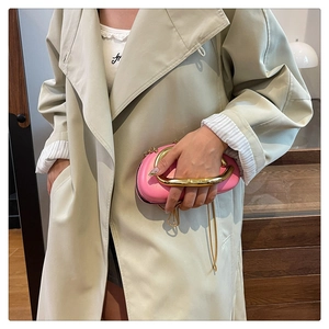 Détail du sac à main en cuir rose avec grande poignée en métal doré et bandoulière