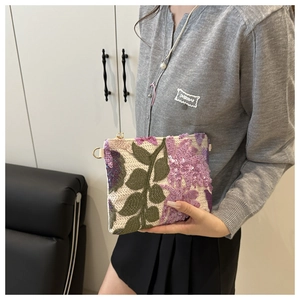 Gros plan sur pochette faite main à paillettes avec broderie florale violette et anneau doré