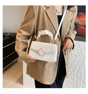 Close-up of white quilted PU leather crossbody bag with pleated handle and gold clasp