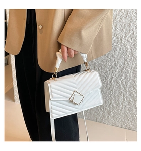 Close-up of white pleated handle handbag with V-quilted texture and geometric square lock