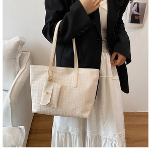 Detail of cream white tote bag with checkered embossing and matching mini pouch accessory