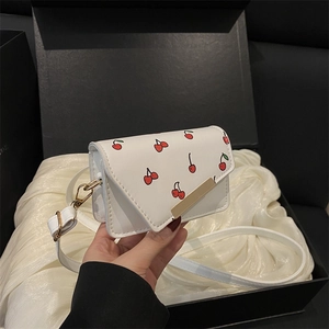Mini white cherry print crossbody bag with gold hardware and a sweet flip-top design