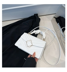 Detailed view of white chevron quilted handbag with gold hardware and ruched top handle