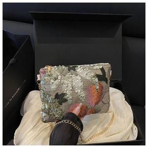 Vue détaillée de la pochette brodée de paillettes florales dans son coffret cadeau