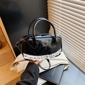 Borsa Boston in pelle verniciata nera con fiocco in metallo e bordo in pizzo bianco