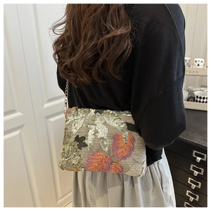 Détail de broderie de feuilles colorées et paillettes sur un sac bohème chic